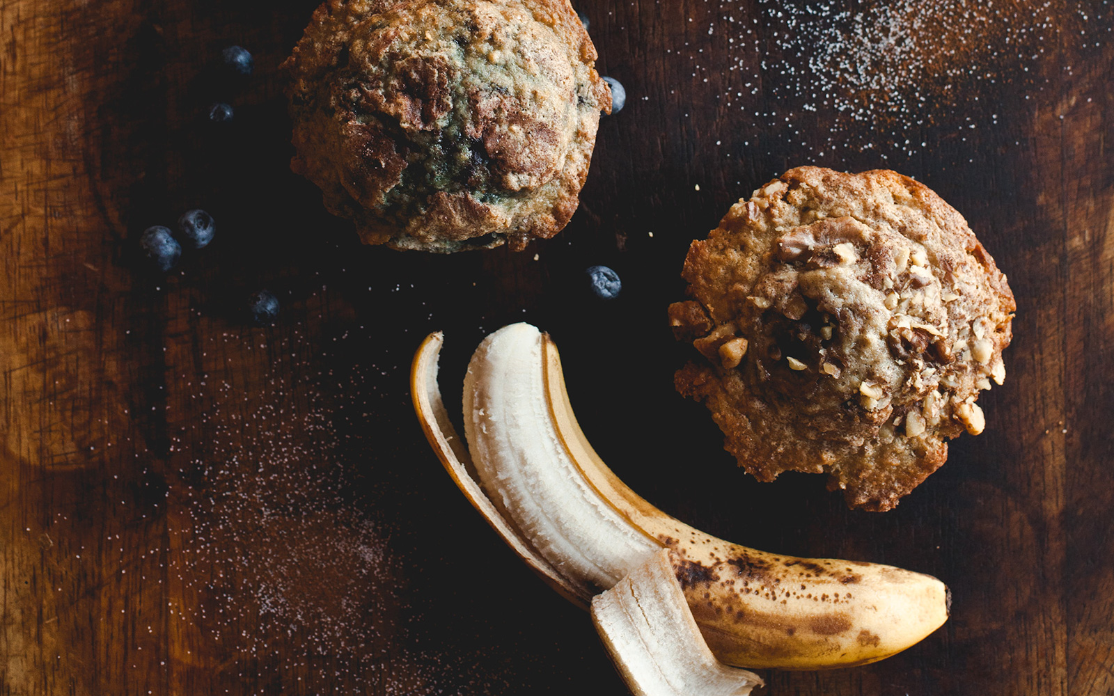 joe-muffins-2 half peeled banana and fresh blueverries next to a banana nut muffin and blueberry muffin
