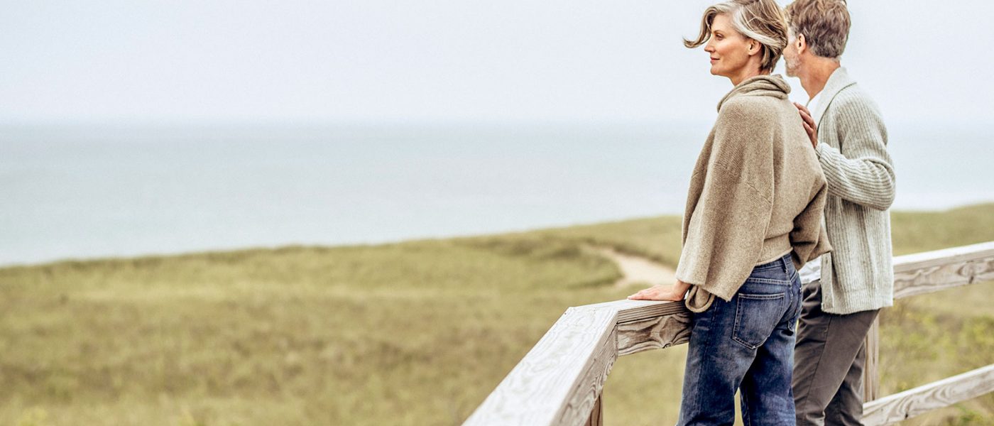 New Buffalo beach features a curvy wooden boardwalk with lovely views of Lake Michigan A mature caucasian couple standing on the wooden boardwalk and looking out over the beach grass and lake Michigan