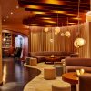 Inspired by Scandinavian and modern design, Marina Grand Resort in New Buffalo, Michigan, offers a full-service resort experience unlike anything else in the region Boutique hotel lobby inside Marina Grand Resort with two half-moon couches, curvy carpet and glass buoys hanging by thick rope from the ceiling