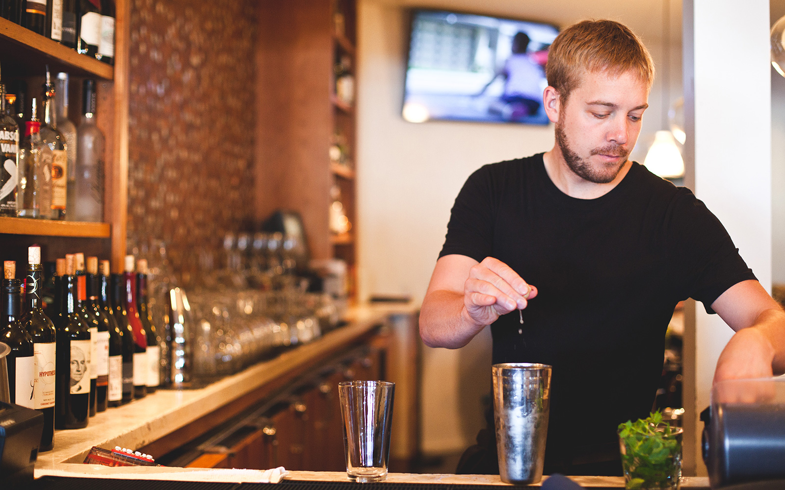 Bentwood Tavern bartender squeezes a lime into a shaker