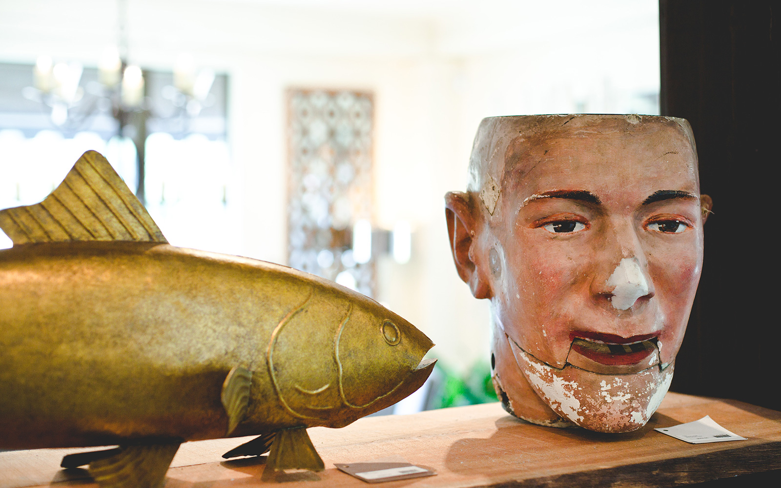 a gold fish statue and a vintage head sculpture with moveable jaw displayed at Mix & Mingle in New Buffalo, Michigan