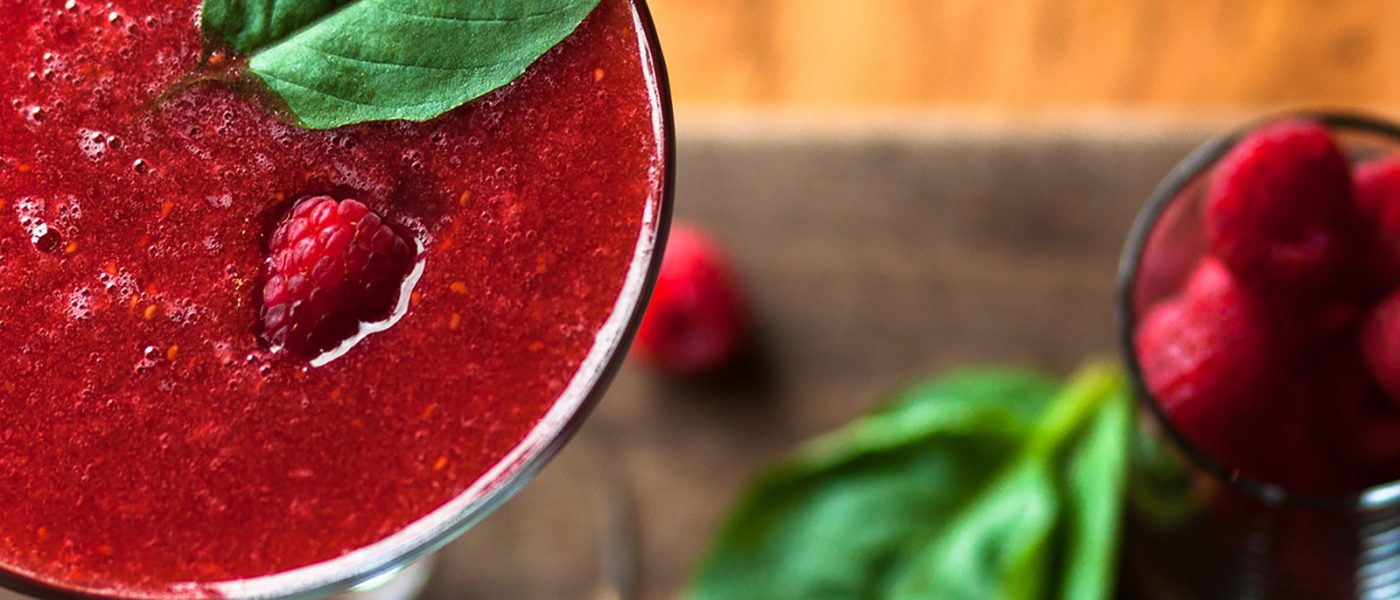 Bentwood Tavern in New Buffalo, Michigan is known for unique seasonal cocktails, like this raspberry basil martini The view from above of a seasonal cocktail with raspberry puree, garnished with a raspberry and basil leaf - available at Bentwood Tavern bar