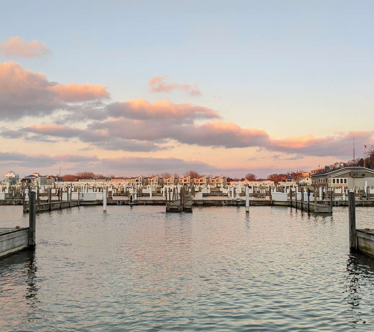 Winter view of the marina with a pink and blue sky and blue water at Marina Grand Resort in New Buffalo, Michigan.
